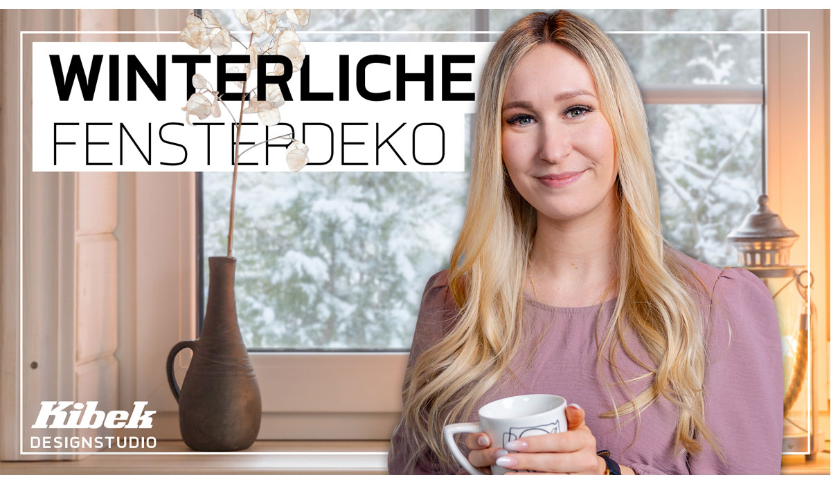 Frau hält Tasse, lächelt vor Fenster mit Schneelandschaft, Text: Winterliche Fensterdeko.